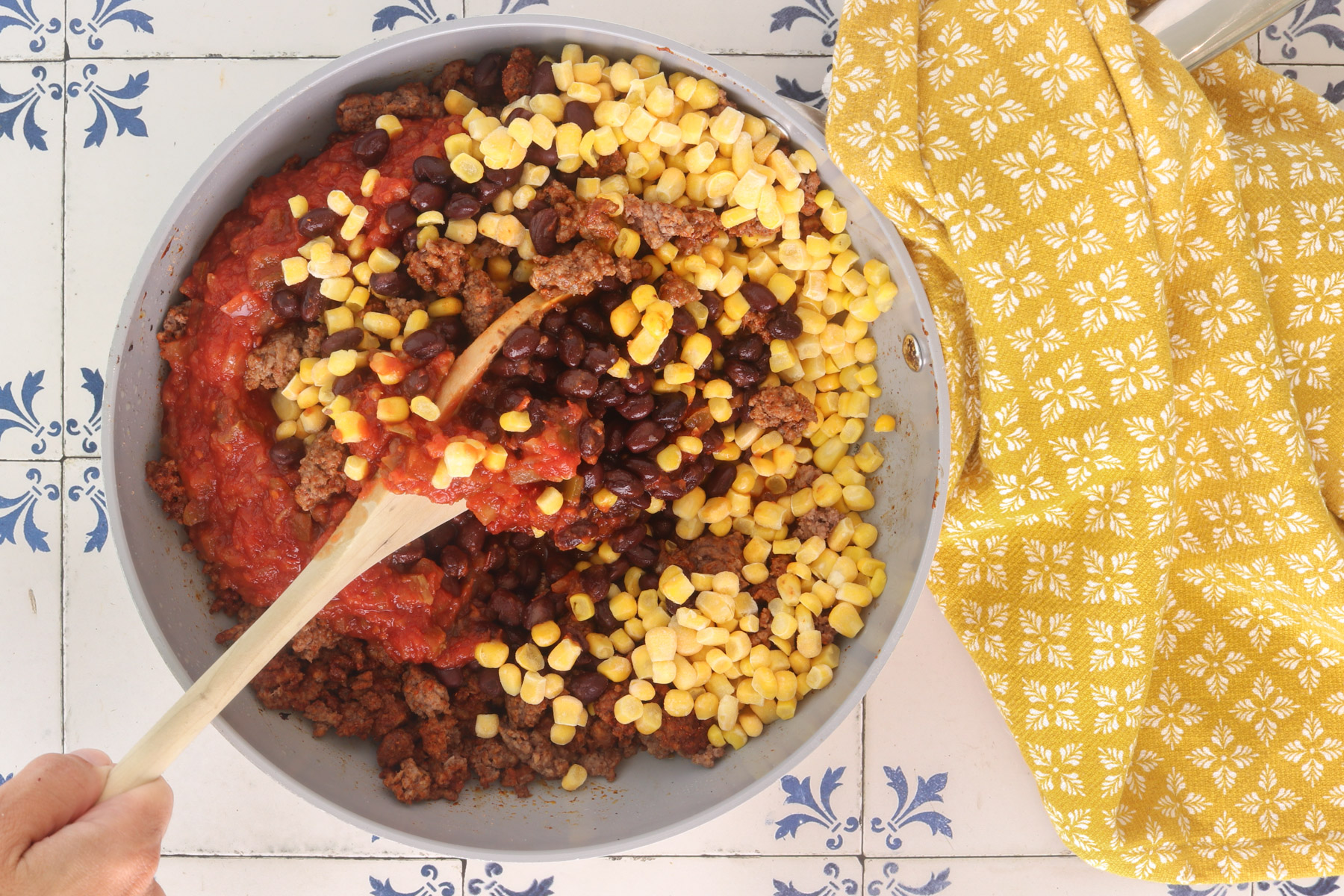 Ground beef, black beans, corn, and salsa added to a skillet for loaded Mexican sweet potato filling.