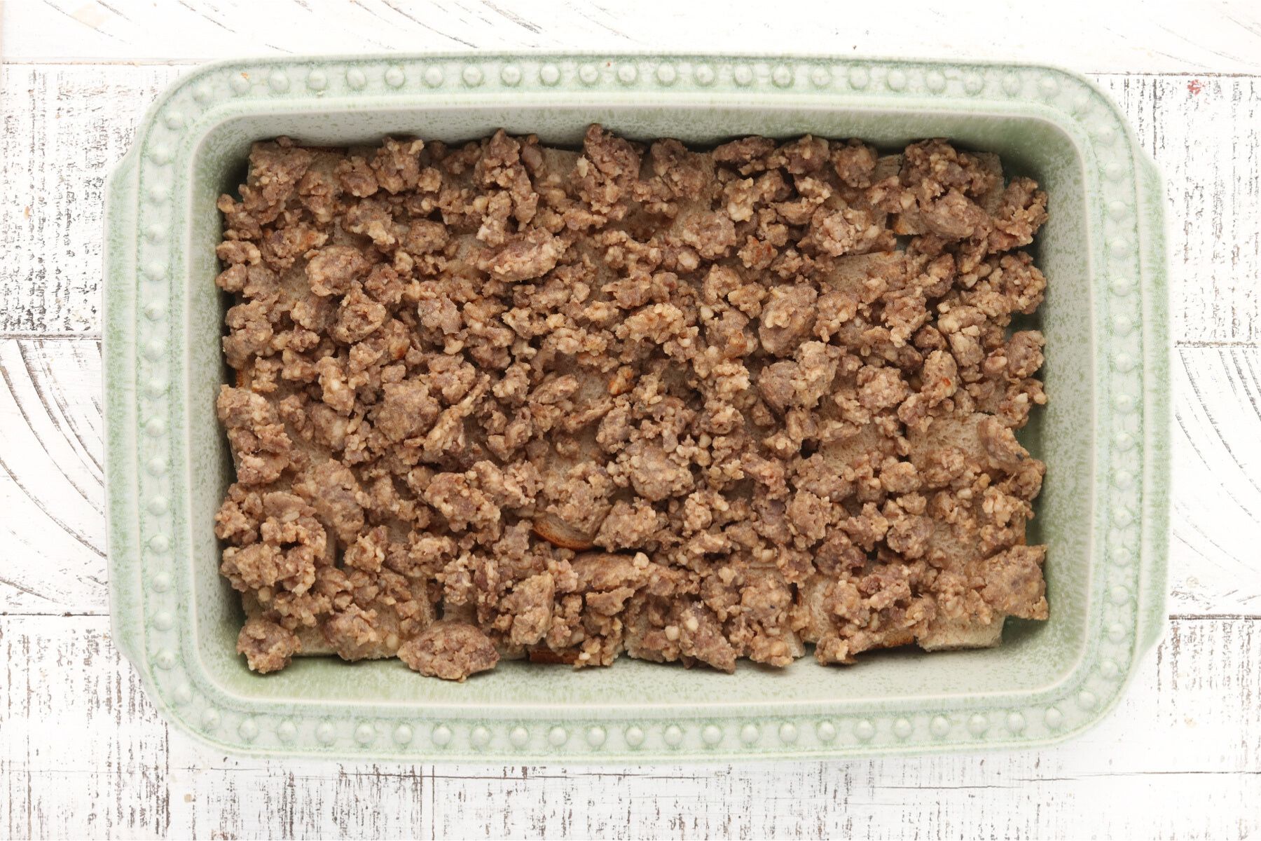 Step 3 - Cottage Cheese Egg Bake. Spread cook sausage on top of the cubed bread. 