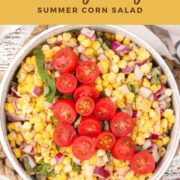 Easy Corn Salad in a white bowl and garnished with basil and cherry tomatoes.