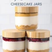 High protein cheesecake jar with a graham cracker crust, creamy cheesecake layer, berry compote topping, and fresh raspberries, blueberries, and blackberries.