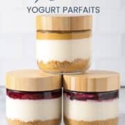 High protein cheesecake jar with a graham cracker crust, creamy cheesecake layer, berry compote topping, and fresh raspberries, blueberries, and blackberries.