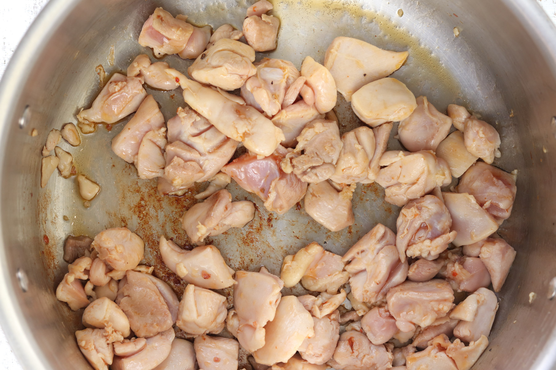 Lightly browning chicken in a large pot.