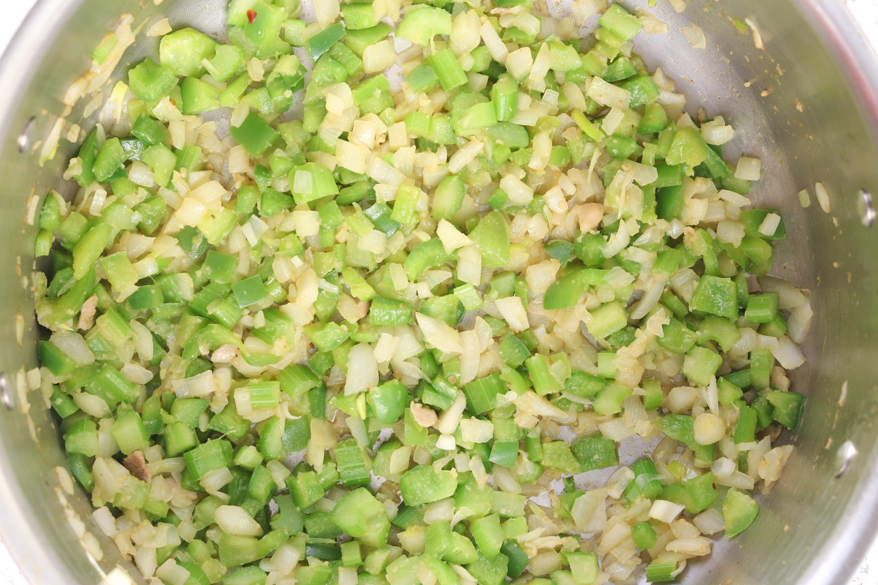 Diced onion, green bell pepper, and celery softening in the pot to build the jambalaya base.