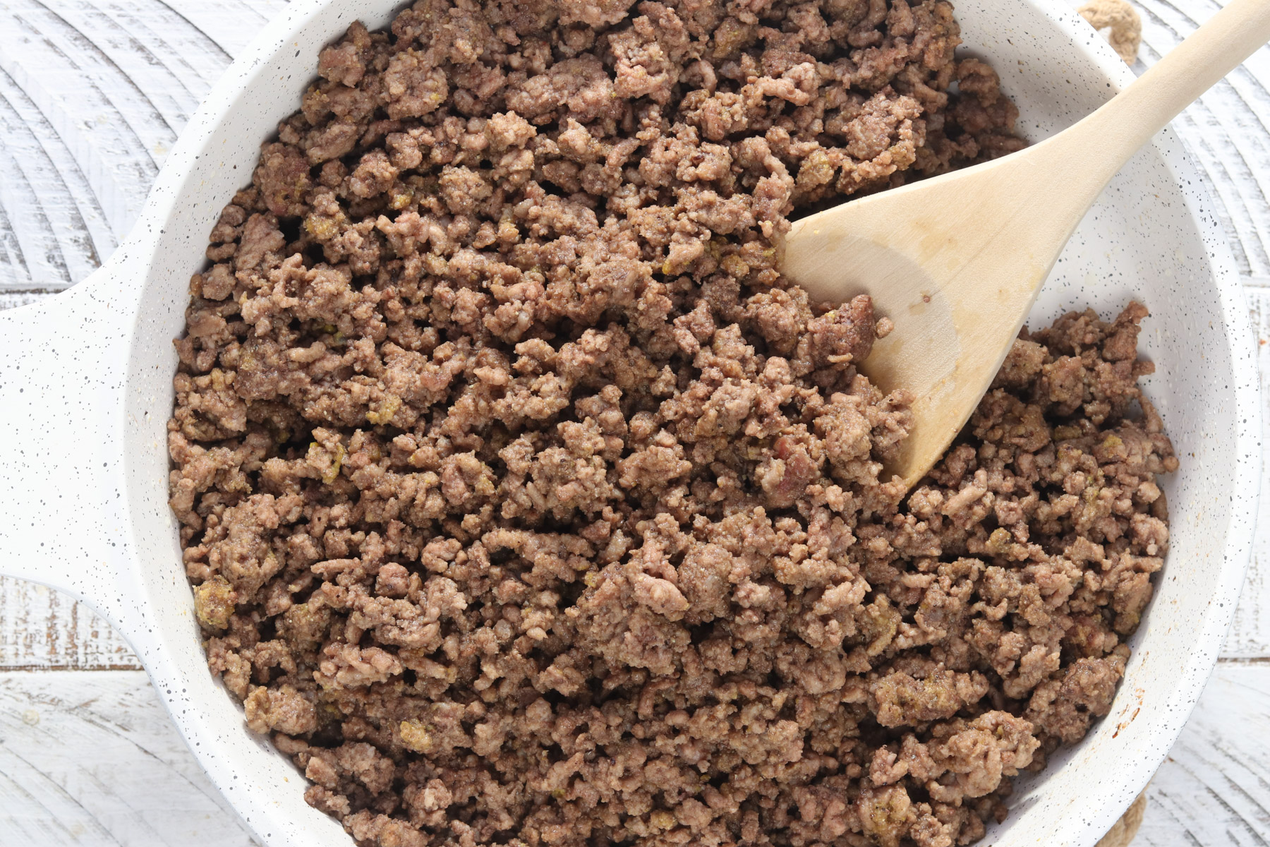 seasoned ground beef cooking in a skillet for burger bowls