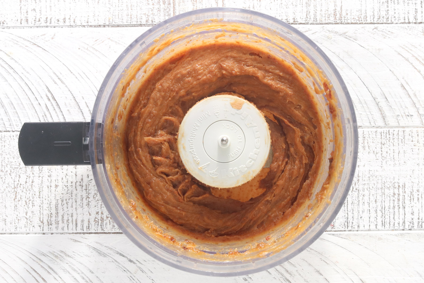 Date caramel blended smooth in a food processor with peanut butter, maple syrup, and salt for healthy snickers bars.