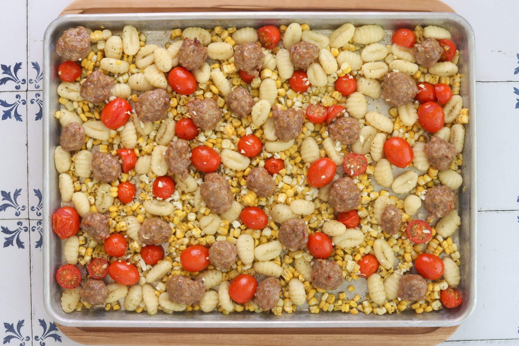 Roasted sheet pan gnocchi with Italian sausage, corn and blistered tomatoes before adding the spinach and cream.