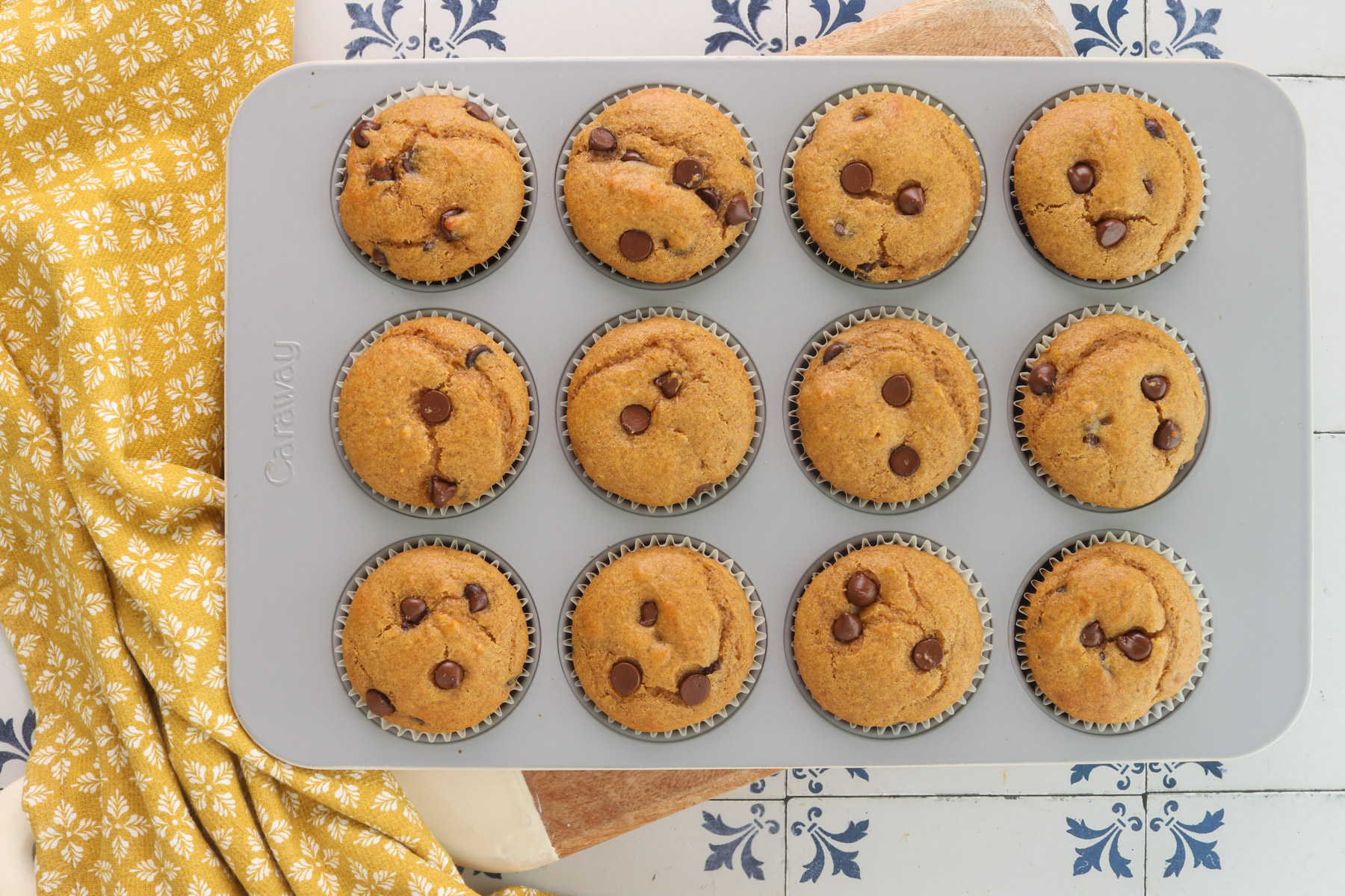 Pumpkin protein muffins with chocolate chips baked in a 12-cup muffin pan with paper liners.