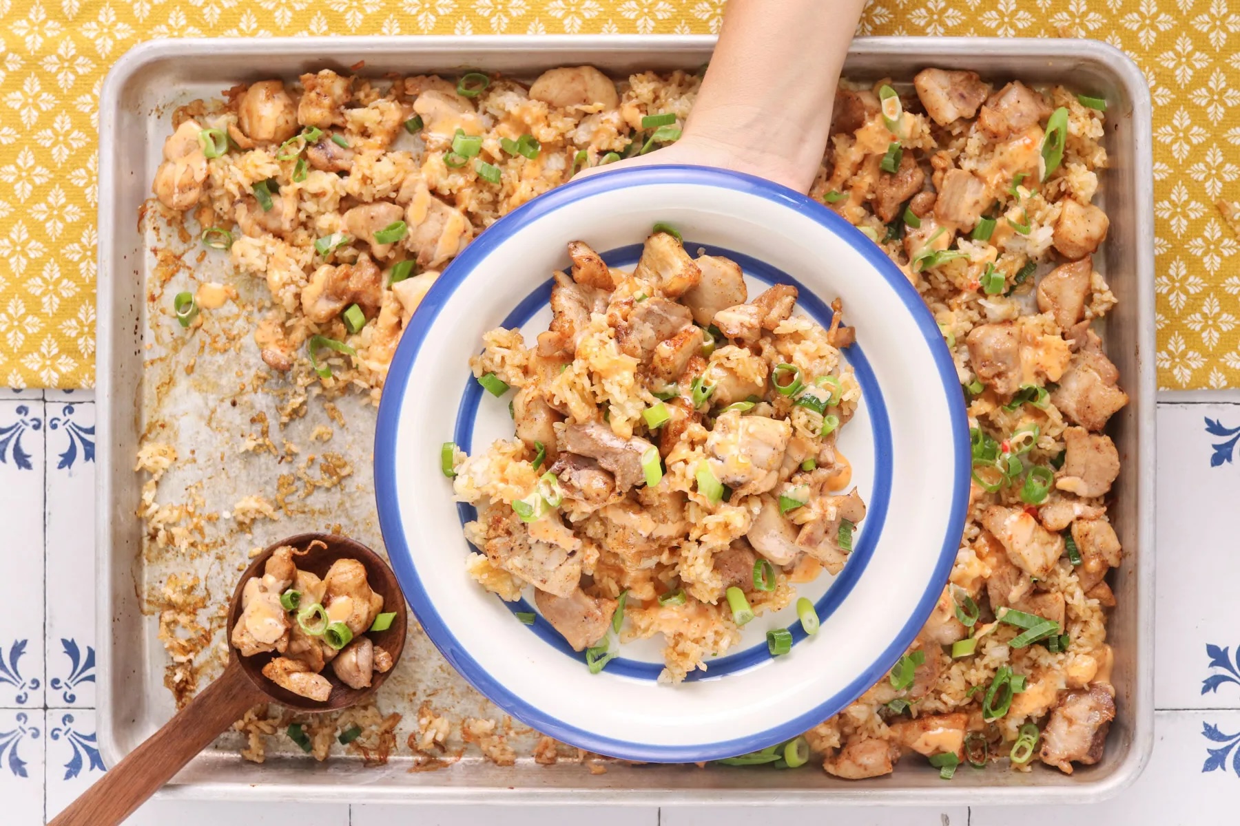 Sheet pan bang bang chicken with crispy rice, creamy bang bang sauce and sliced green onions, served straight from the pan.