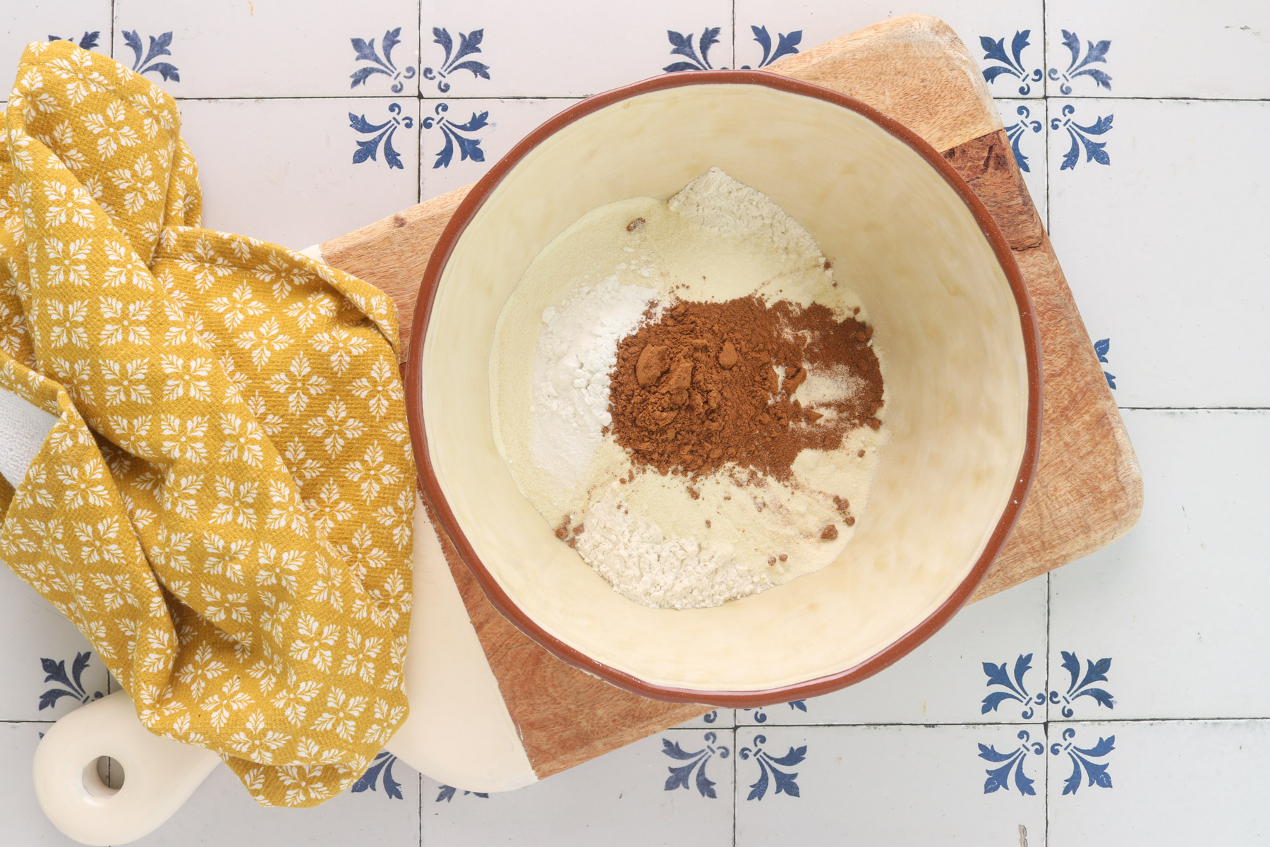 Dry ingredients for pumpkin protein muffins, including flour, vanilla protein powder, baking powder, baking soda, cinnamon, pumpkin pie spice and salt in a mixing bowl.